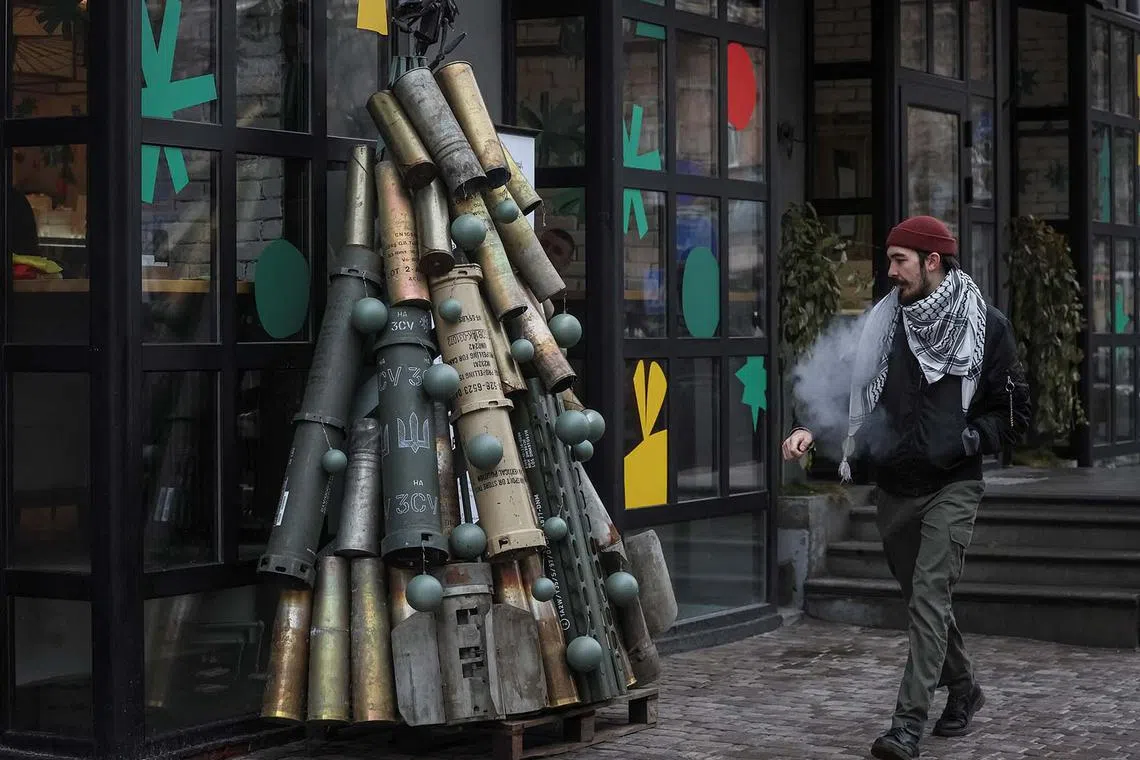 A man passes by a symbolic Christmas tree made from used artillery shells and parts of rockets who were transported to the Ukrainian capital from the front line, amid Russia's attack on Ukraine, in central Kyiv, Ukraine December 19, 2023. REUTERS/Gleb Garanich