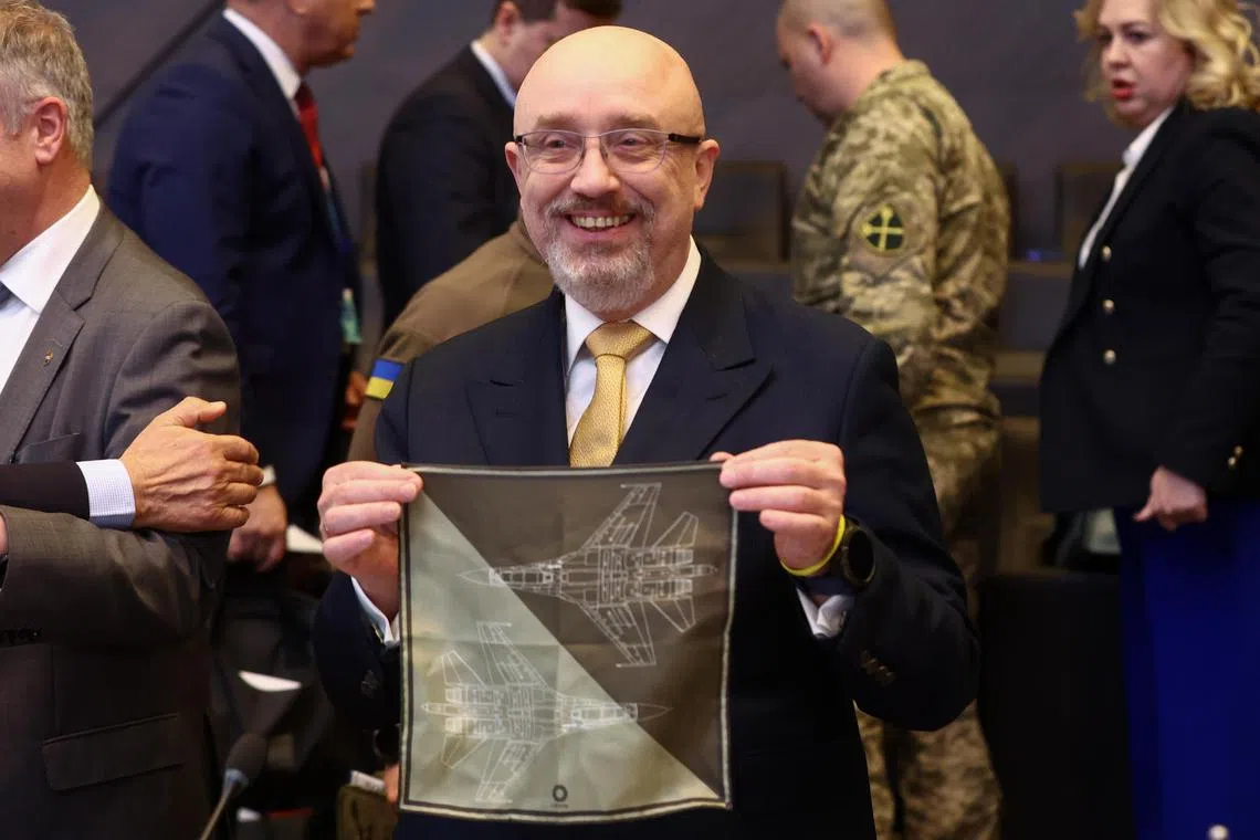 Ukraine's Defense Minister Oleksii Reznikov shows a handkerchief featuring an F-35 fighter jet at the start of a meeting of Nato defence ministers in Brussels, Belgium.