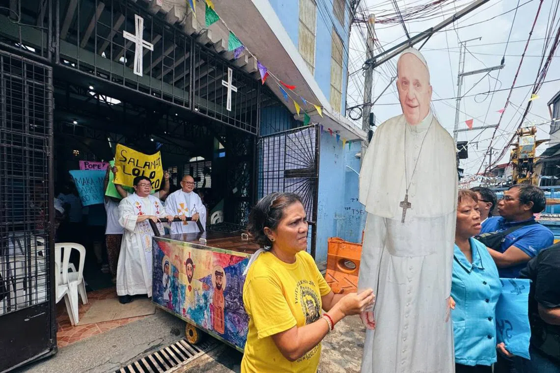 Filipino activist-priest Robert Reyes leading a procession in the slums of Manila to mark the start of the papal conclave on May 7.