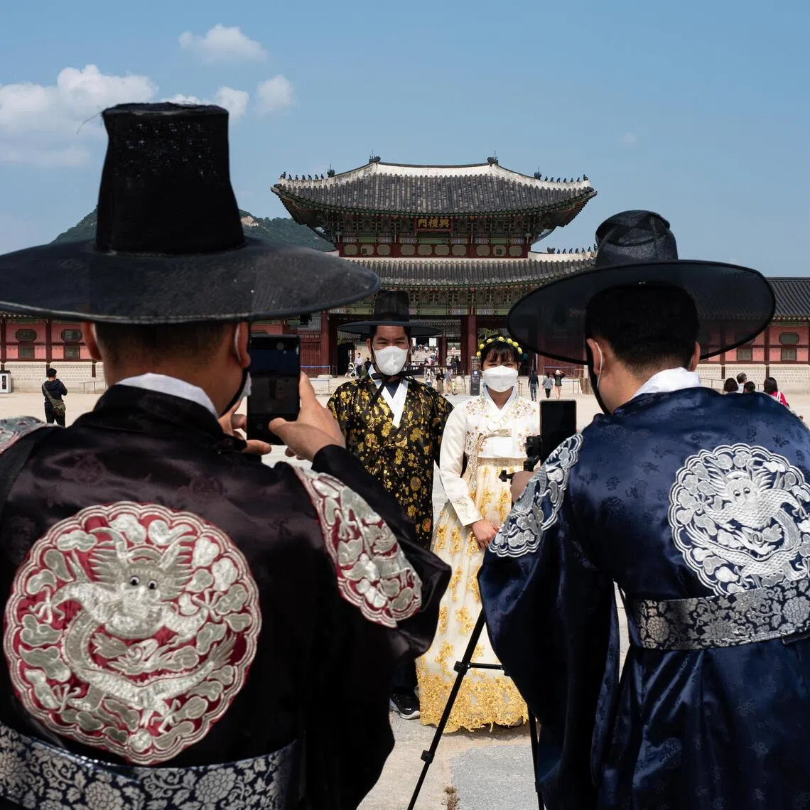 Tourists wearing a 'Hanbok', a Korean traditional costume, pose for photos during a visit at the Gyeongbokgung Palace in Seoul, South Korea.