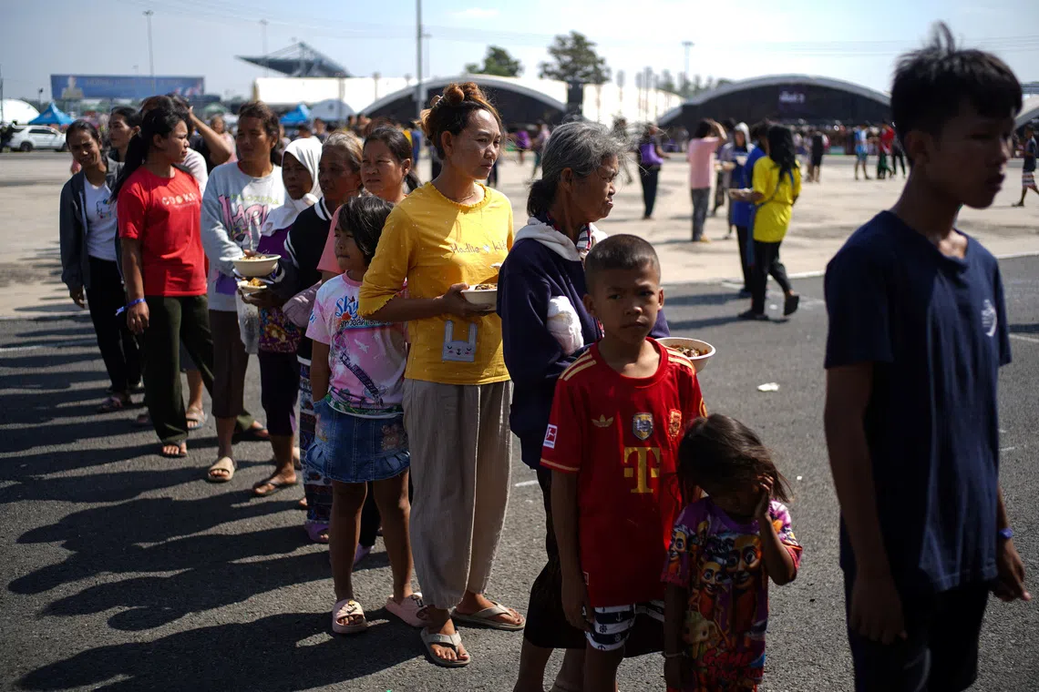 Displaced people queue for food at a temporary shelter amid deadly clashes between Thailand and Cambodia along a disputed border area, in Buriram province, Thailand, December 9, 2025. REUTERS/Athit Perawongmetha