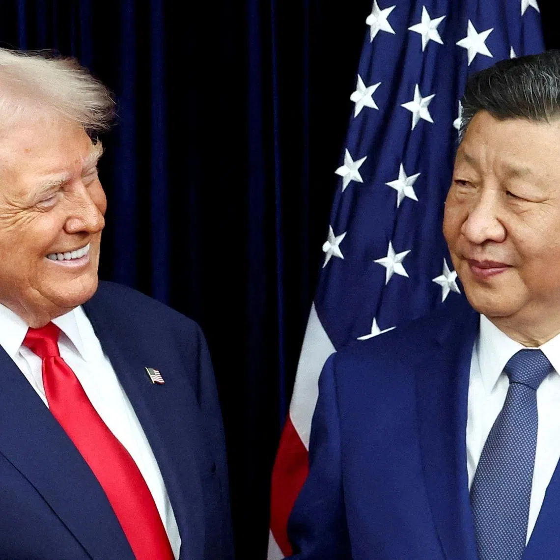 FILE PHOTO: U.S. President Donald Trump and Chinese President Xi Jinping react as they hold a bilateral meeting at Gimhae International Airport, on the sidelines of the Asia-Pacific Economic Cooperation (APEC) summit, in Busan, South Korea, October 30, 2025. REUTERS/Evelyn Hockstein/File Photo