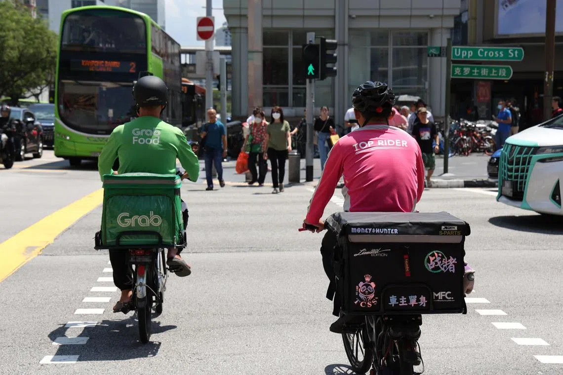 GrabFood和Foodpanda送餐员骑脚车送餐。