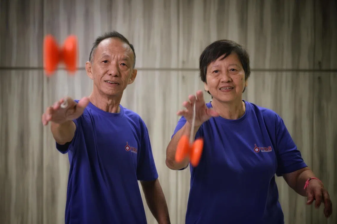 Mr Tan Boon Guan, 69, and his wife, Madam Kwek Siew Noi, 68, doing yoyo tricks at Fei Yue Active Ageing Centre in Hougang on Nov 28, 2024.  They picked up the hobby as part of the Lien Foundation's Seniors Go programme to introduce older people to new experiences.