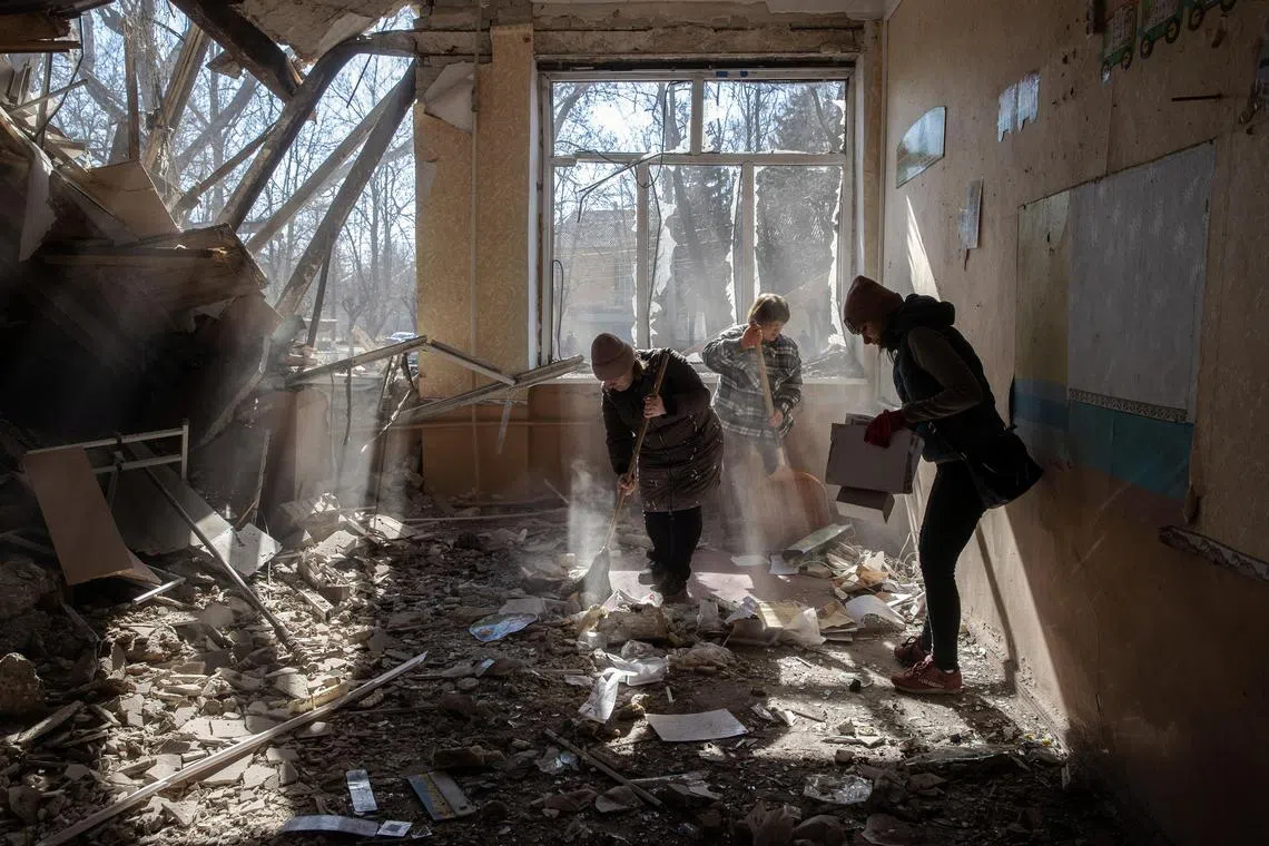 Local residents clear out the rubble after a school was hit by Russian forces in Kramatorsk, in eastern Ukraine, on Monday, March 6, 2023. In a rare public acknowledgment of a cross-border strike, Ukrainian special forces said one of their drones had destroyed an unmanned watch tower in Russia’s Bryansk region. (Tyler Hicks/The New York Times)