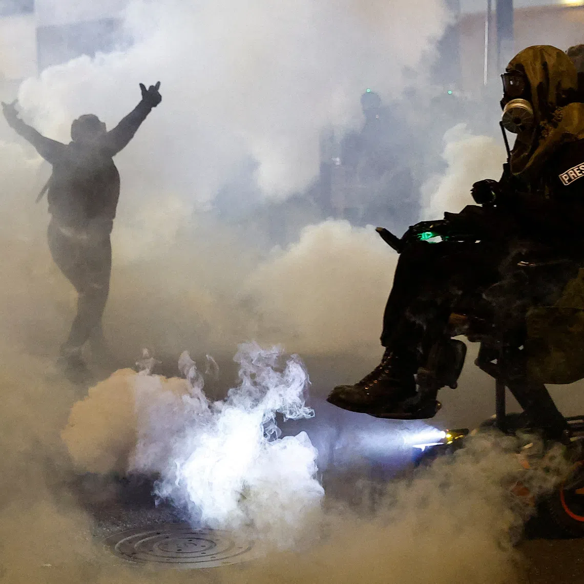 Law enforcement officers advancing to disperse demonstrators near the US Immigration and Customs Enforcement headquarters in Portland, Oregon, on Oct 4.