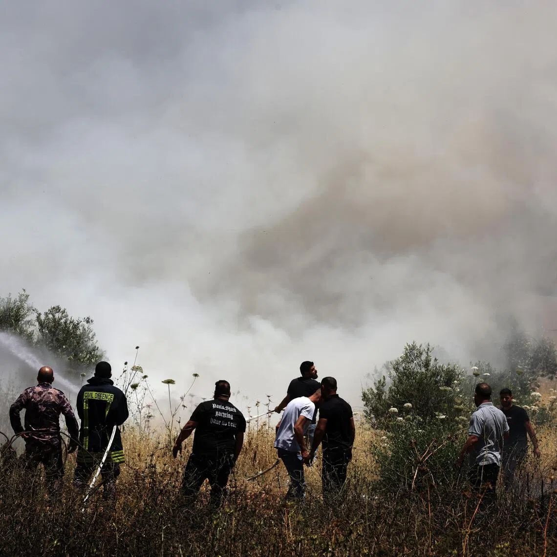 Palestinians trying to extinguish smouldering farms, following an attack by Israeli settlers in the village of Huwwara, near Nablus, in the West Bank, on June 6.