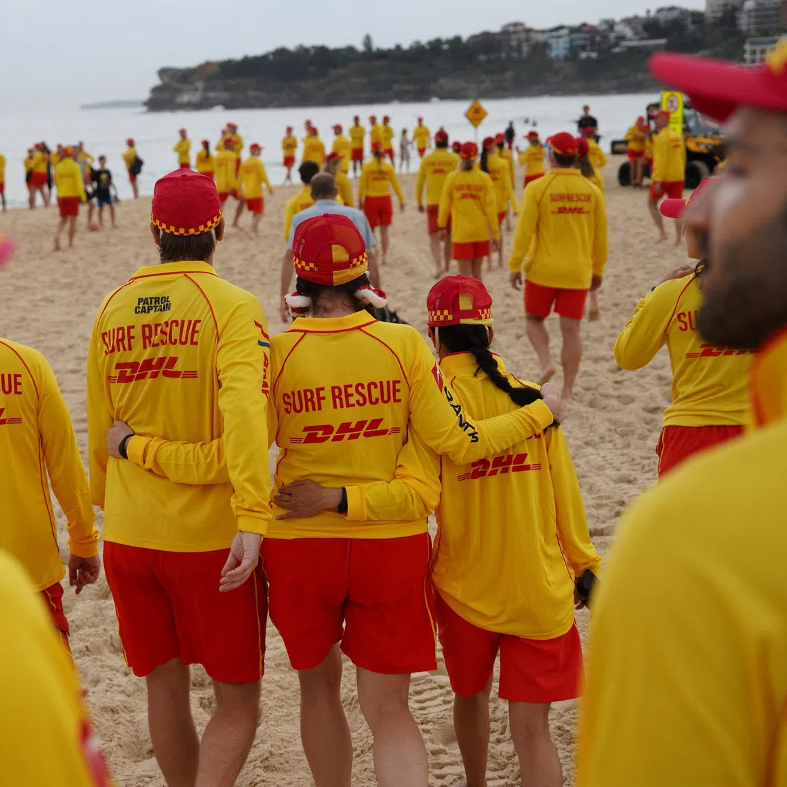 Members of Bondi Surf Life Saving Club and North Bondi Surf Life Saving Club walk towards Bondi Beach during an event to stand shoulder to shoulder as they observe three minutes of silence to honour victims, responders, and lifesavers following the mass shooting that targeted a Jewish Hanukkah celebration at Bondi Beach on December 14, in Sydney, Australia, December 20, 2025. REUTERS/Audrey Richardson