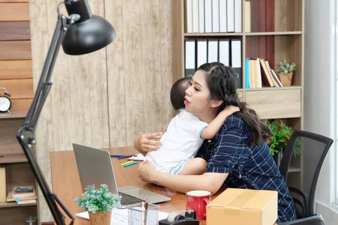 woman taking care of child while working, balancing career and motherhood