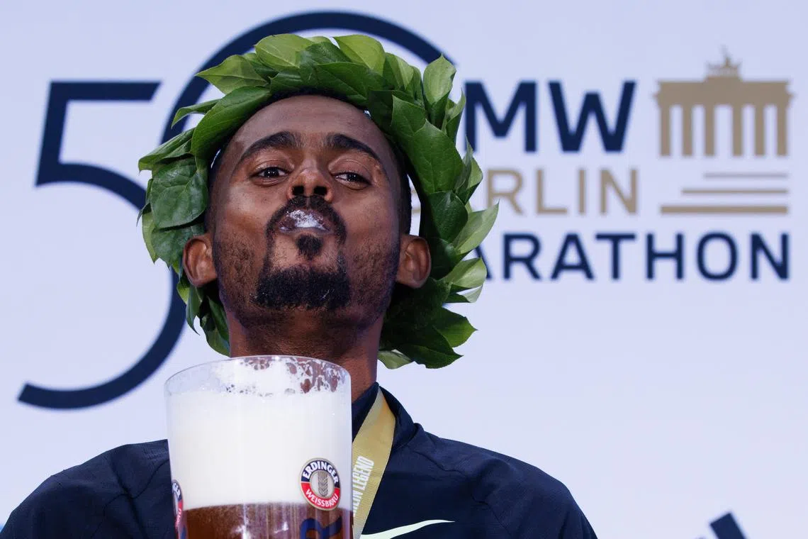 Winner Milkesa Mengesha of Ethiopia reacting as he drinks beer during the medal ceremony for the men's race of the 50th Berlin Marathon in Germany on Sept 29.