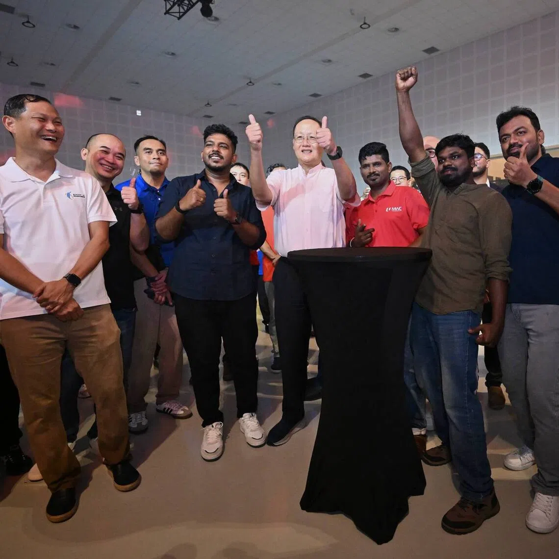 Manpower Minister Tan See Leng (centre, in pink shirt) at an event marking International Migrants Day on Dec 14.