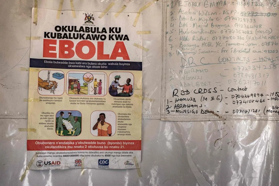 A poster displaying Ebola emergency contact numbers is pinned to a tent at the Busunga border crossing between Uganda and the Democratic Republic of Congo in Bundibugyo on May 18.