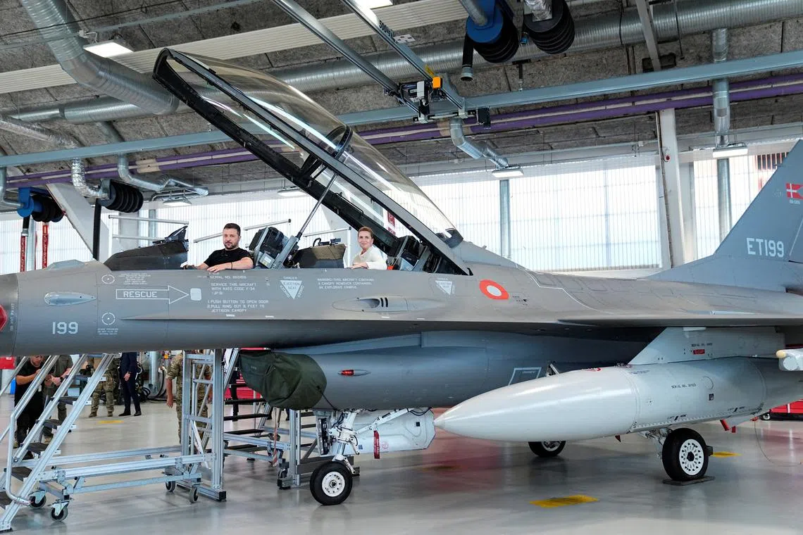 FILE PHOTO: Ukrainian President Volodymyr Zelenskiy and Danish Prime Minister Mette Frederiksen sit in a F-16 fighter jet at Skrydstrup Airbase in Vojens, Denmark, August 20, 2023. Ritzau Scanpix/Mads Claus Rasmussen via REUTERS/File Photo