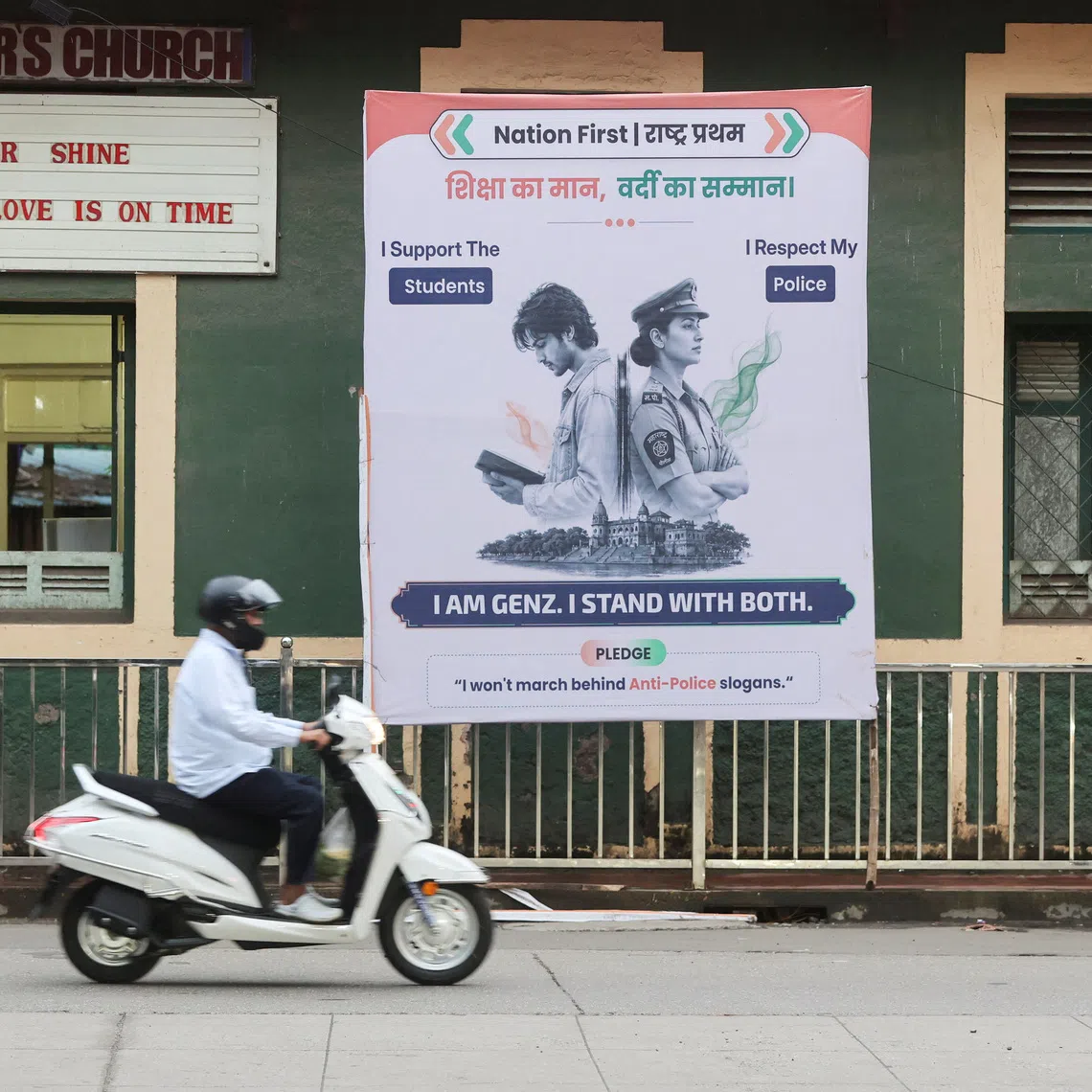 A commuter rides a scooter past a hoarding depicting a student and a police officer along a pavement in Mumbai, India, August 5, 2026. REUTERS/Francis Mascarenhas