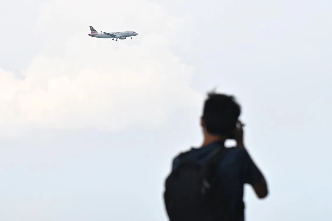 A plane spotter trying to capture the arrival of the Aero Dili Airline's Airbus A320 aircraft carrying the Pope, together with the papal entourage, at Changi Beach Park, on Sept 11, 2024.