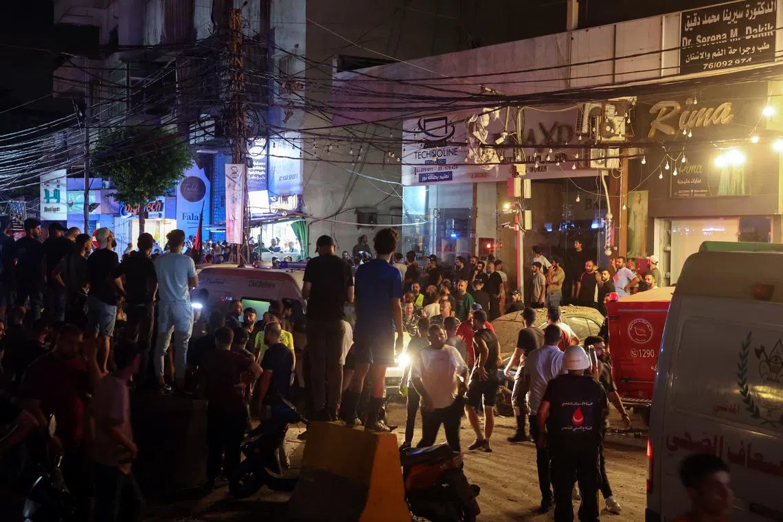 Civil defense members and people gather near a site hit by what security sources said was a strike on Beirut's southern suburbs, Lebanon July 30, 2024. REUTERS/Mohamed Azakir