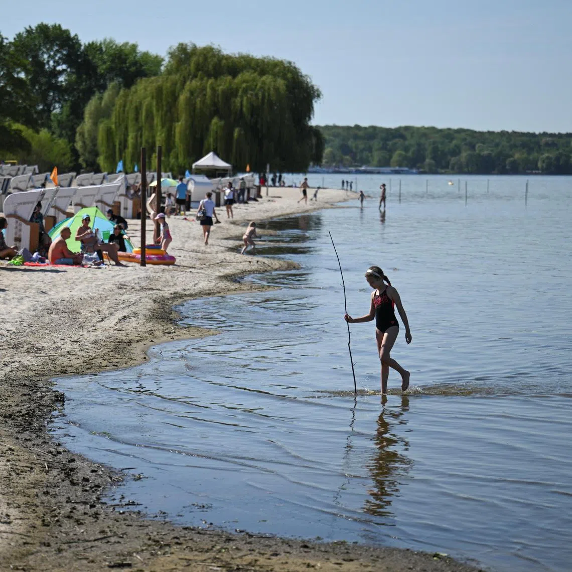 A girl walks in the water of lake Wannsee at the start of the bathing season in Berlin.