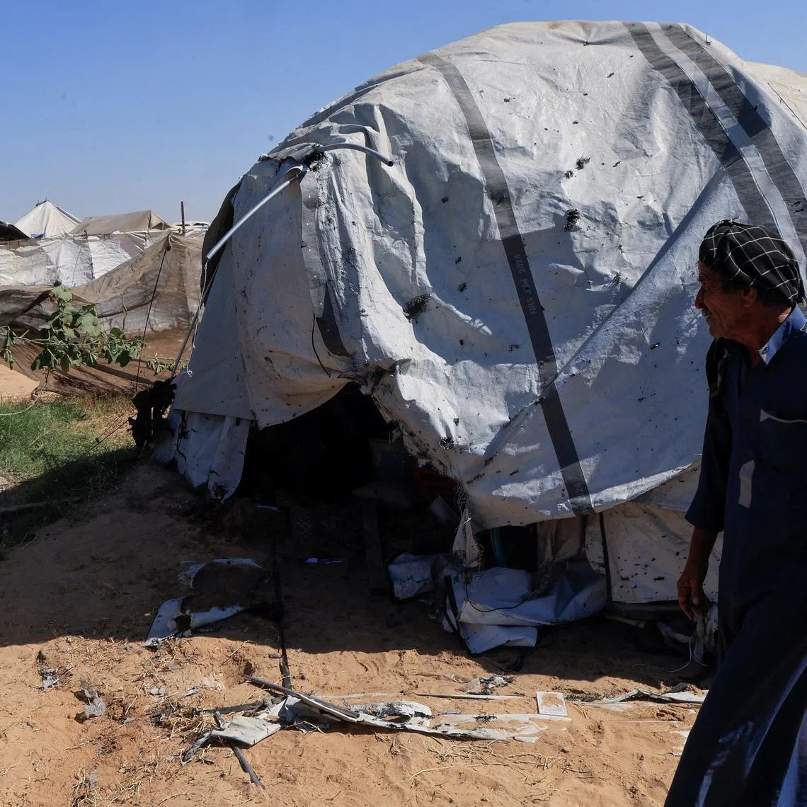 Palestinians inspect the site of an Israeli strike on a tent in Khan Younis, in the southern Gaza Strip, July 8, 2026. REUTERS/Haseeb Alwazeer