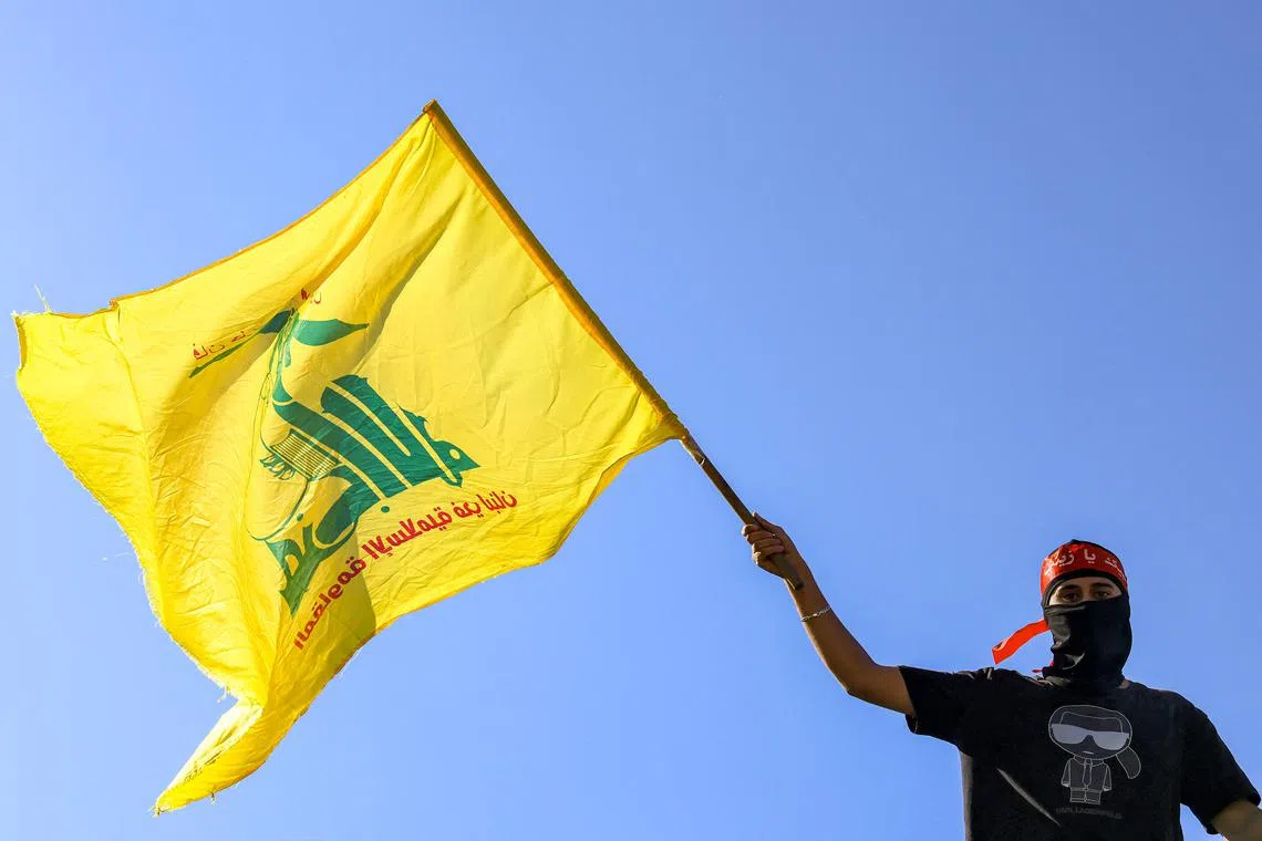A demonstrator waving the flag of Hezbollah in Beirut on Oct 20.