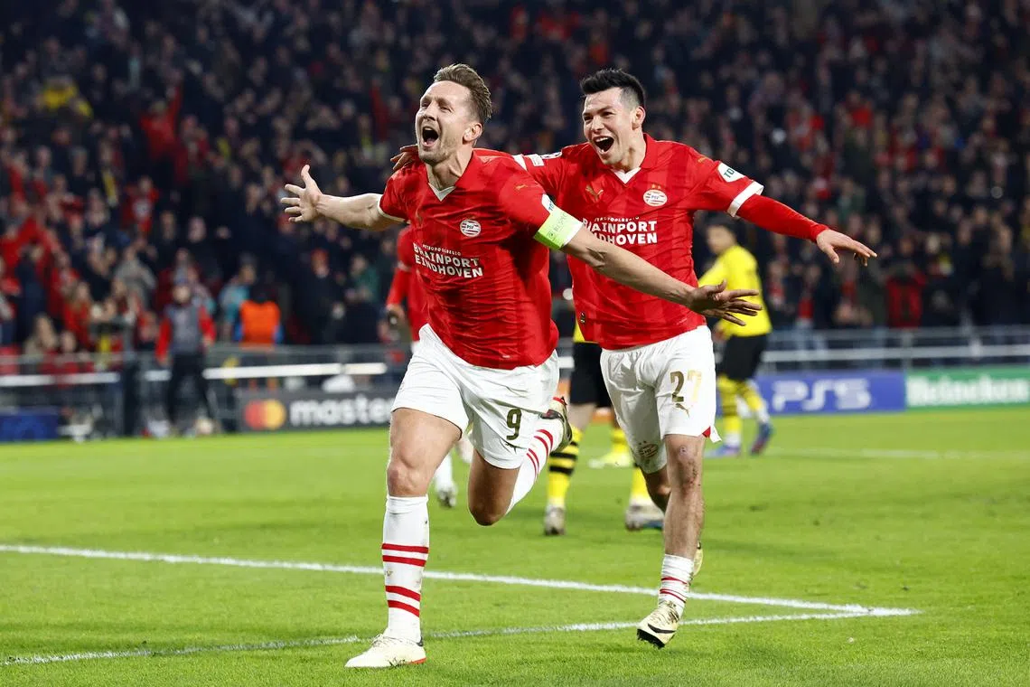 Soccer Football - Champions League - Round of 16 - First Leg - PSV Eindhoven v Borussia Dortmund - Philips Stadion, Eindhoven, Netherlands - February 20, 2024 PSV Eindhoven's Luuk de Jong celebrates scoring their first goal with Hirving Lozano REUTERS/Piroschka Van De Wouw