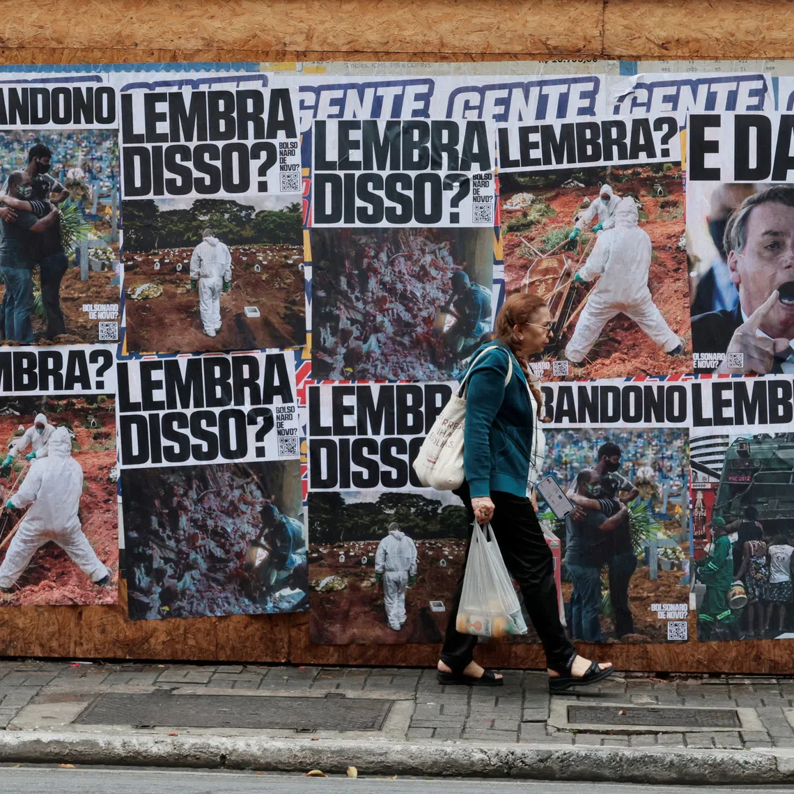 A pedestrian passes posters referring to former Brazilian President Jair Bolsonaro and the Covid-19 pandemic in the days before the presidential election, with his son, Flavio Bolsonaro, as the Liberal Party (PL) candidate, in Sao Paulo, Brazil, October 1, 2026. REUTERS/Brian Snyder