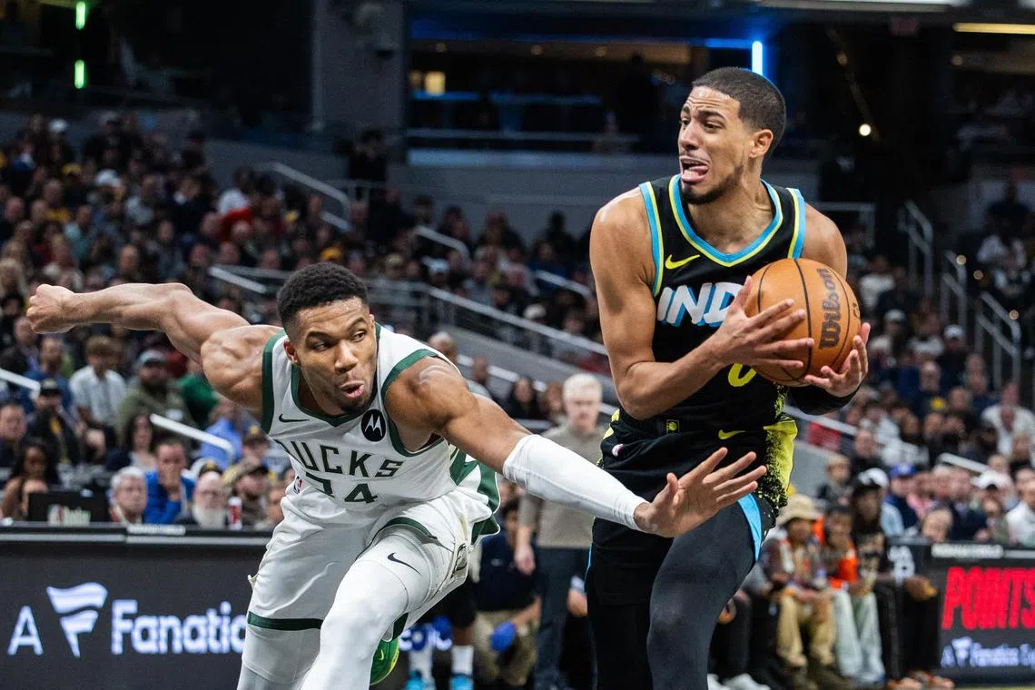 Indiana Pacers guard Tyrese Haliburton dribbles the ball while Milwaukee Bucks forward Giannis Antetokounmpo defends in the second half at Gainbridge Fieldhouse.
