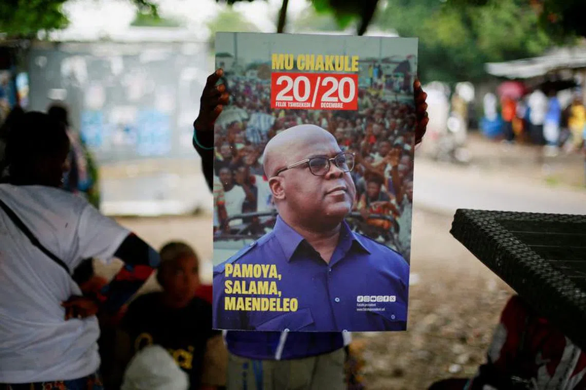 A supporter of holds a portrait of president Felix Tshisekedi of Union for Democracy and Social Progress at their party's headquarters in Kinshasa, Democratic Republic of Congo December 31, 2023. REUTERS/Justin Makangara