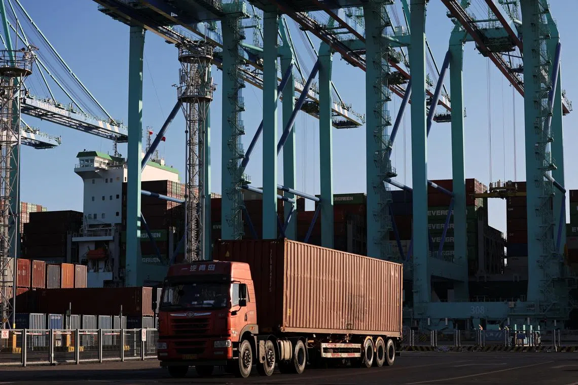 FILE PHOTO: A truck transports a container near gantry cranes unloading containers from a cargo ship, at a port in Tianjin, China February 8, 2025. REUTERS/Florence Lo/File Photo