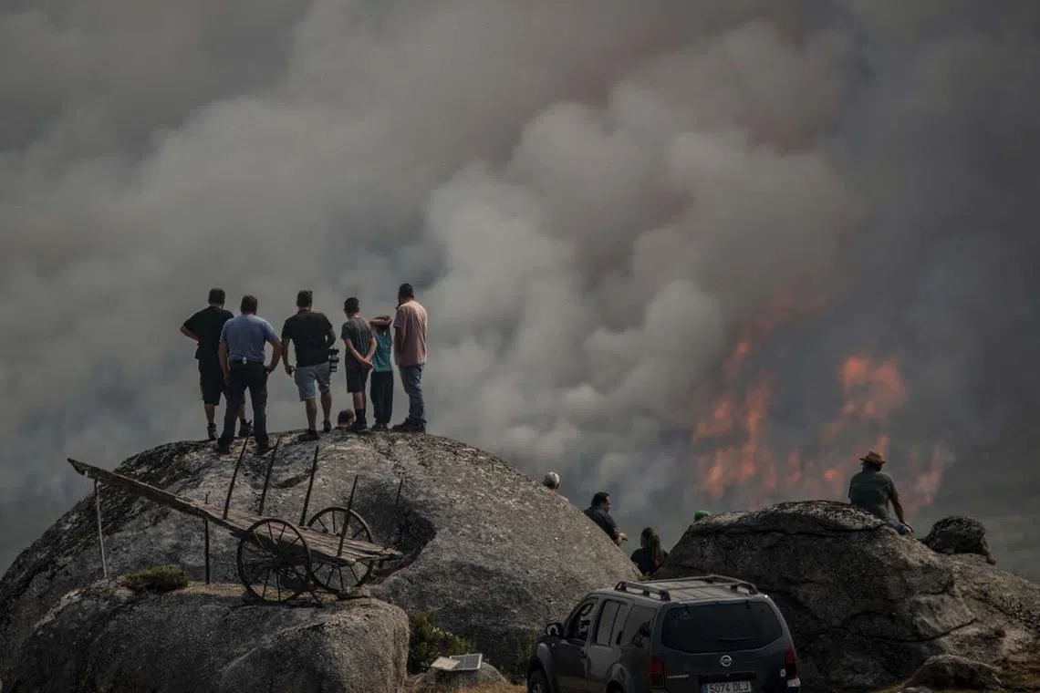 Neighbours looking on as a forest fire burns in Avion, Galicia, Spain, 25 Aug 2025. 