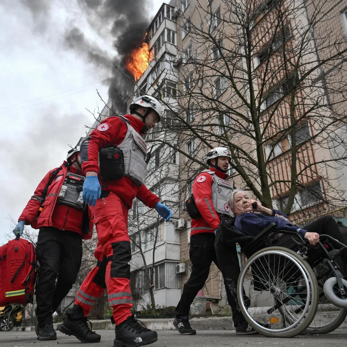 Paramedics assisting a resident after an apartment building was hit by a Russian air strike on Dec 17, in Ukraine's Zaporizhzhia.