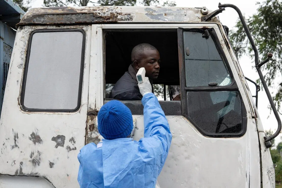 A health worker takes the temperature of a truck driver passing through the Kanyaruchinya checkpoint in the Democratic Republic of the Congo on May 20.