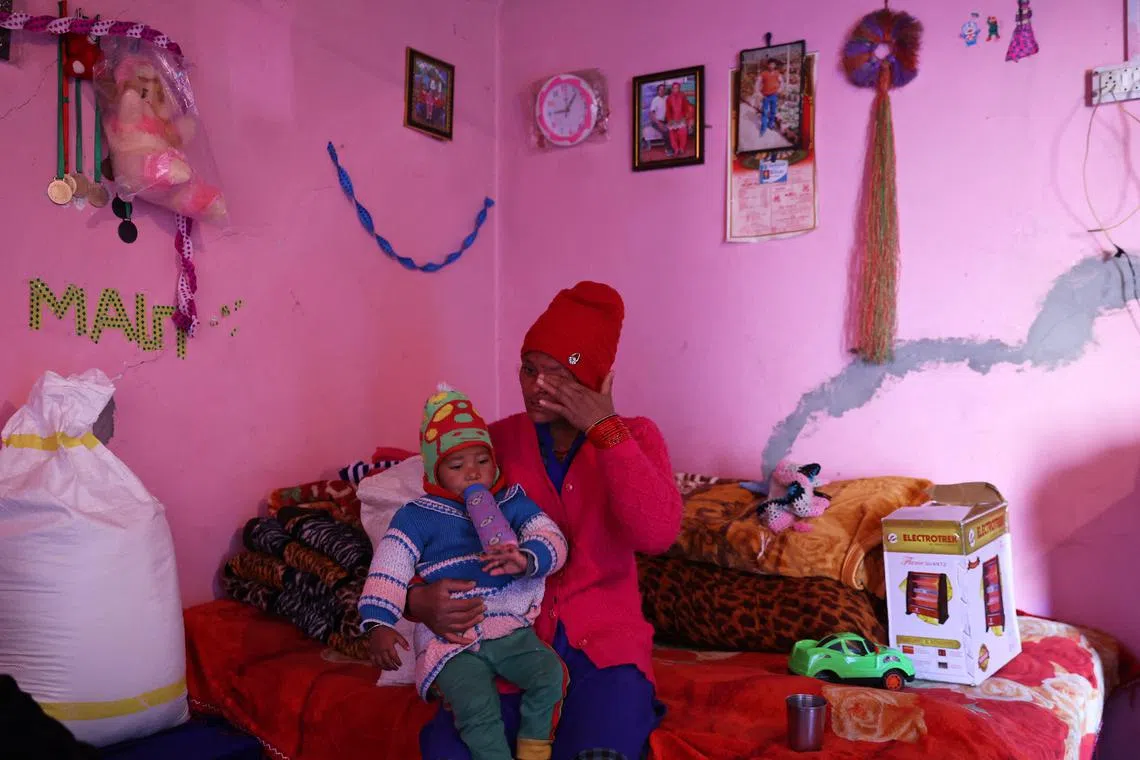 Rajeshwari Devi, 34, cries as she holds her daughter Meghana, 3, at their house, which developed cracks following rapid urban expansion, in the Gandhinagar area of Joshimath, in the northern state of Uttarakhand, India, Jan 16, 2023. Devi, along with her family, sleeps in a municipal building converted to a night shelter and only spends time in their house during the day. Devi has four daughters, of which, two live with her, while the other two stay with a relative due to the deterioration of her house. 