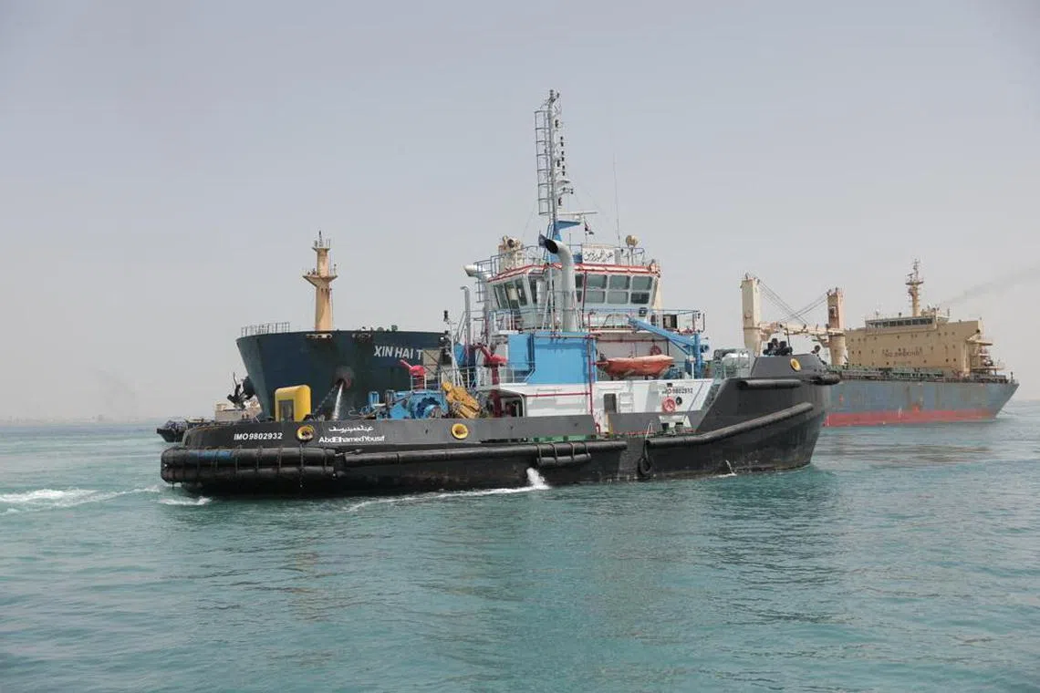 A tugboat in the Suez Canal works to refloat a cargo ship in May 2023.