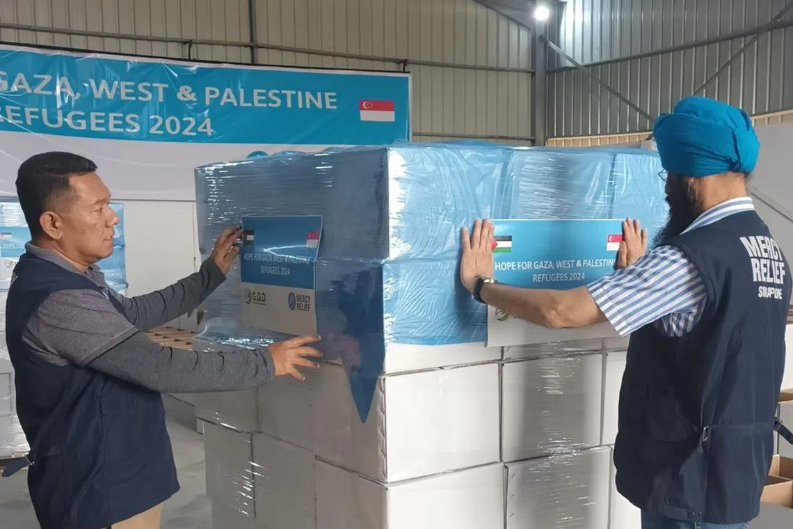 Mercy Relief chairman Satwant Singh (right) and board member Chairul Fahmy Hussaini preparing the food packages.