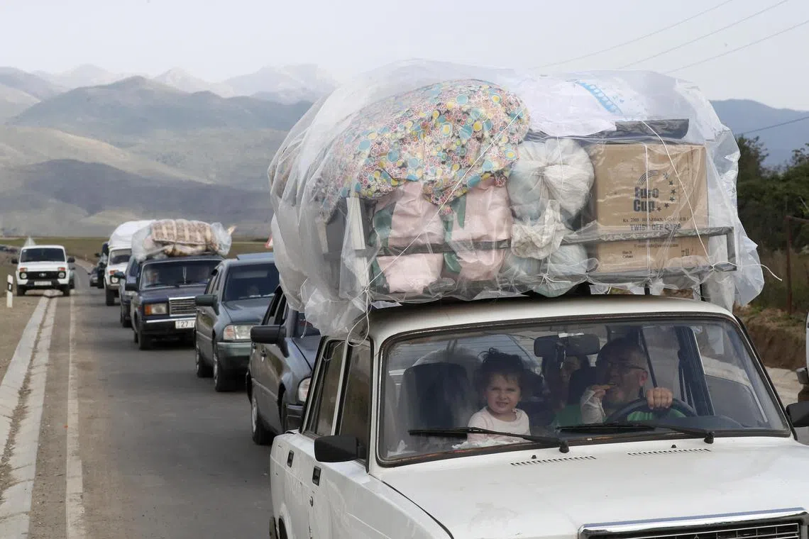 Ethnic Armenians from Nagorno-Karabakh cross the border with Azerbaijan by car, carrying their belongings with them, near the village of Kornidzor, Armenia.