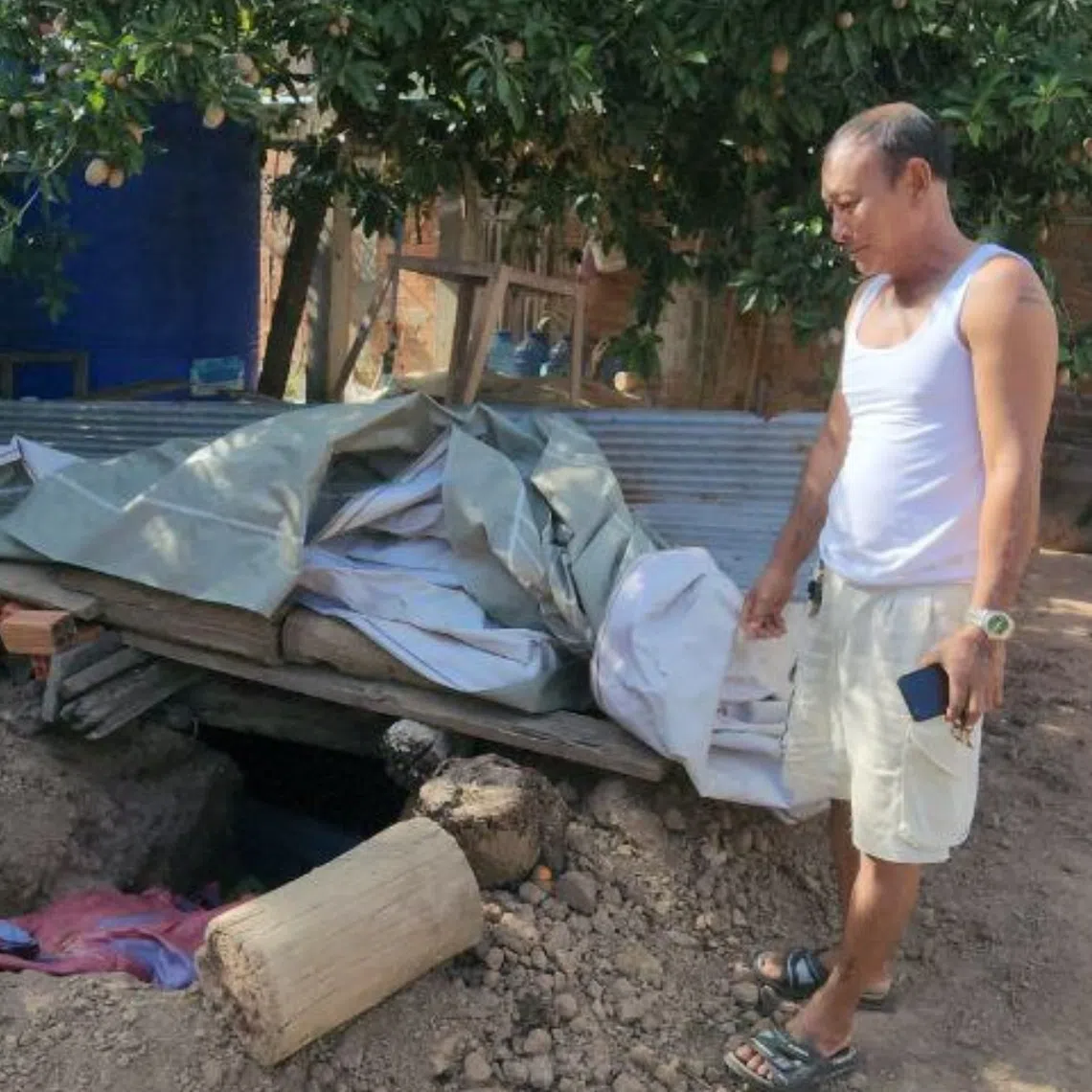 Farmer Yem Mal spent four hours digging a bunker in his backyard. 