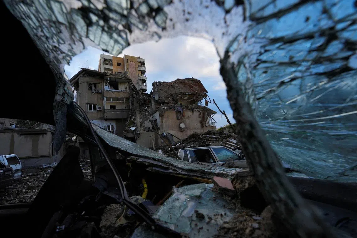 A damaged building is pictured through the wreckage of a vehicle, in the aftermath of Israeli strikes on Beirut's southern suburbs, amid the ongoing hostilities between Hezbollah and Israeli forces, Lebanon November 26, 2024. REUTERS/Mohammed Yassin