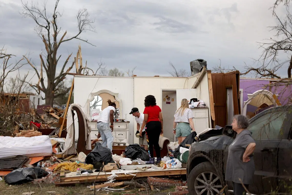 Residents recovering possessions and securing homes that were damaged by Friday's tornado on March 26.
