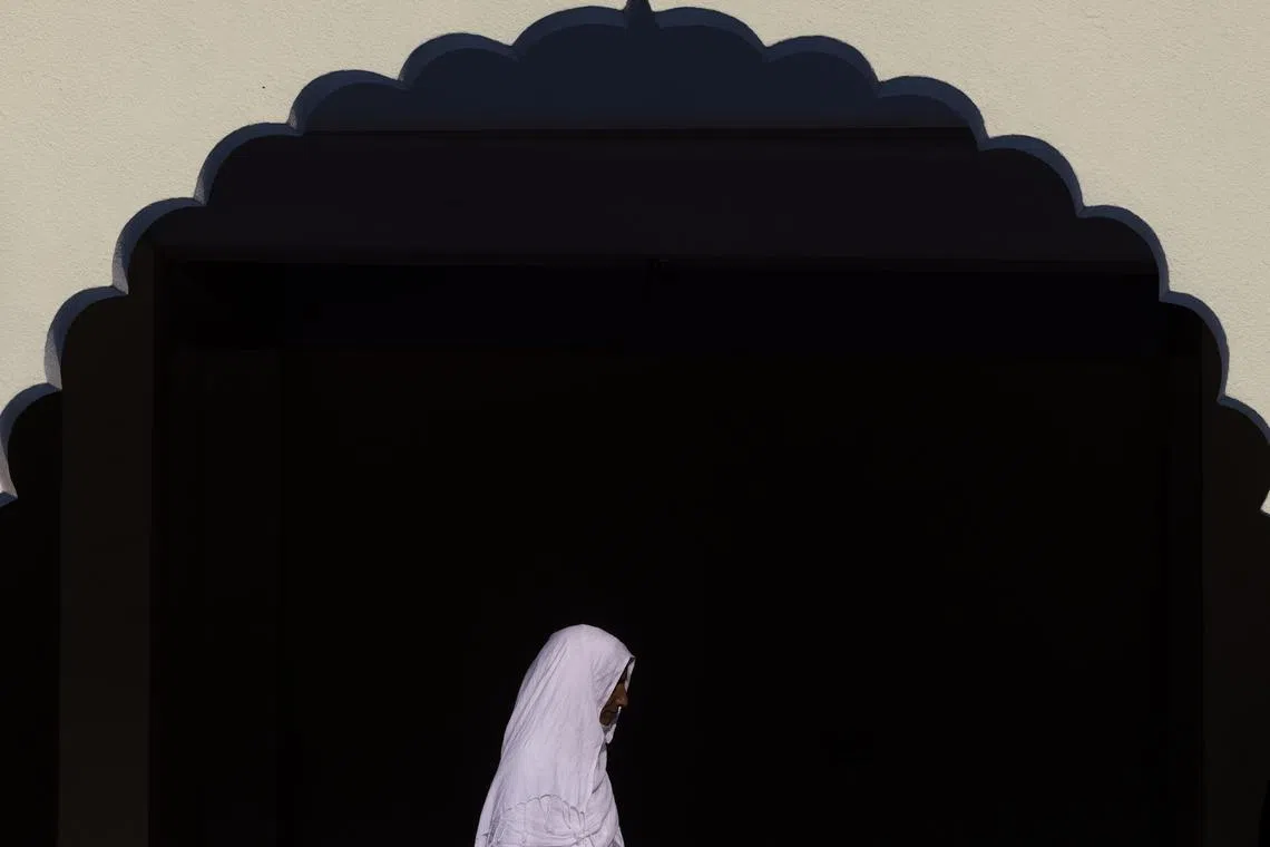 A Nepalese Muslim pilgrim walking at the mosque, Kashmiri Mashjid in Kathmandu, Nepal, before leaving for the holy city of Mecca, in Saudi Arabia, on May 15, 2024. 