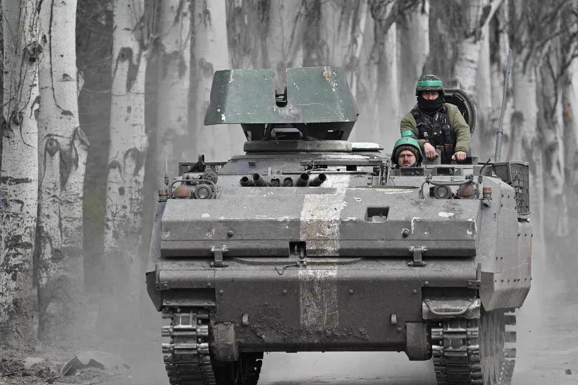Ukrainian servicemen ride on an armoured personnel carrier, on a road near Bakhmut, in Ukraine's Donetsk region.