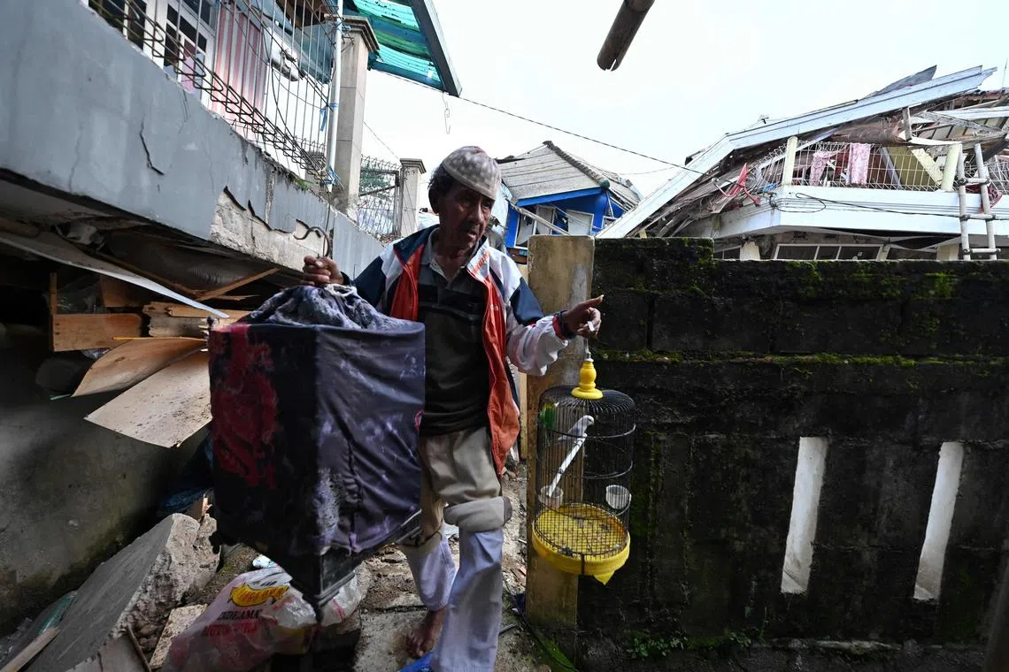 A man saves his pets following a 5.6-magnitude earthquake that killed at least 162 people, with hundreds injured and others missing in Cianjur on Nov 22, 2022. 