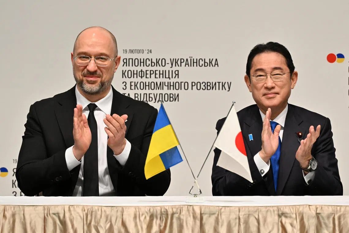 Ukraine's Prime Minister Denys Shmyhal (left) and Japanese Prime Minister Fumio Kishida (right) attend a memorandum of cooperation exchange ceremony during the Japan-Ukraine Conference for Promotion of Economic Growth and Reconstruction.