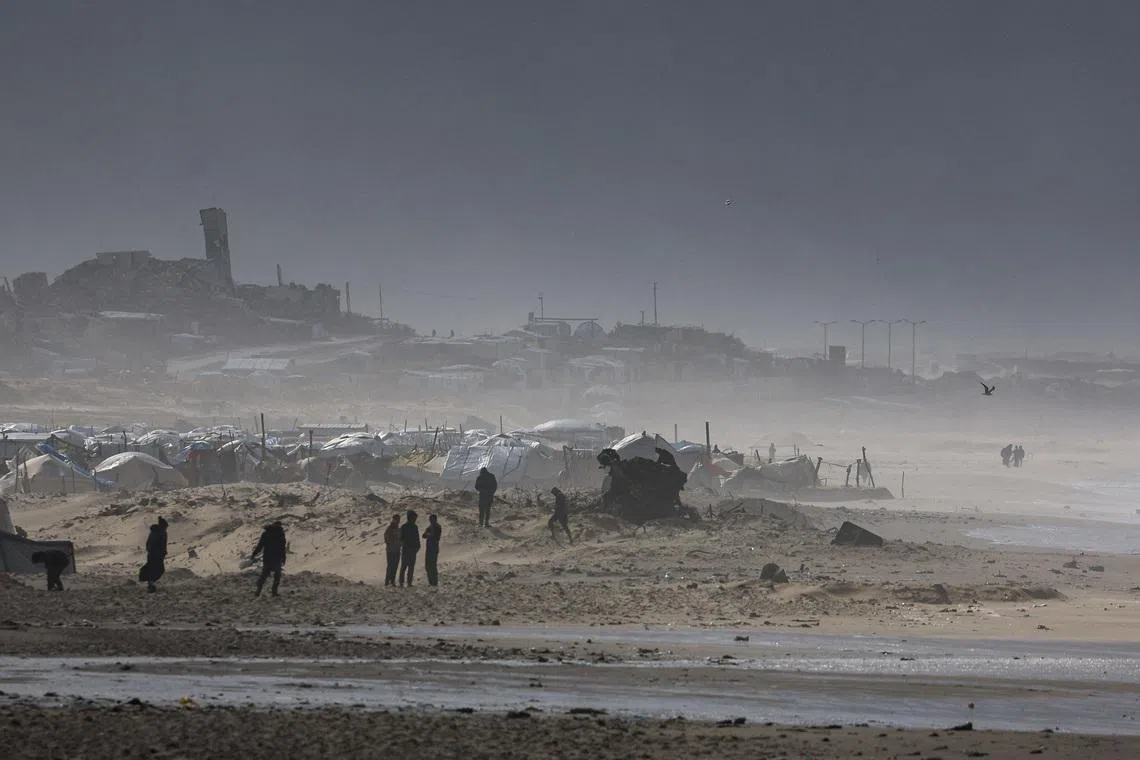 Palestinians gather near tents sheltering displaced people, amid a windstorm, in Gaza City, January 13, 2026. REUTERS/Dawoud Abu Alkas