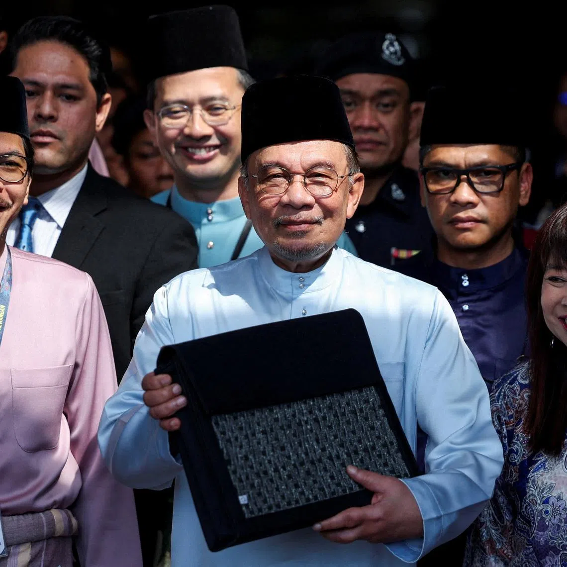 FILE PHOTO: Malaysia's Prime Minister and Finance Minister, Anwar Ibrahim, holds the 2026 national budget document at the Finance Ministry building as he departs for Parliament to table the budget, in Putrajaya, Malaysia, October 10, 2025. REUTERS/Hasnoor Hussain/File Photo