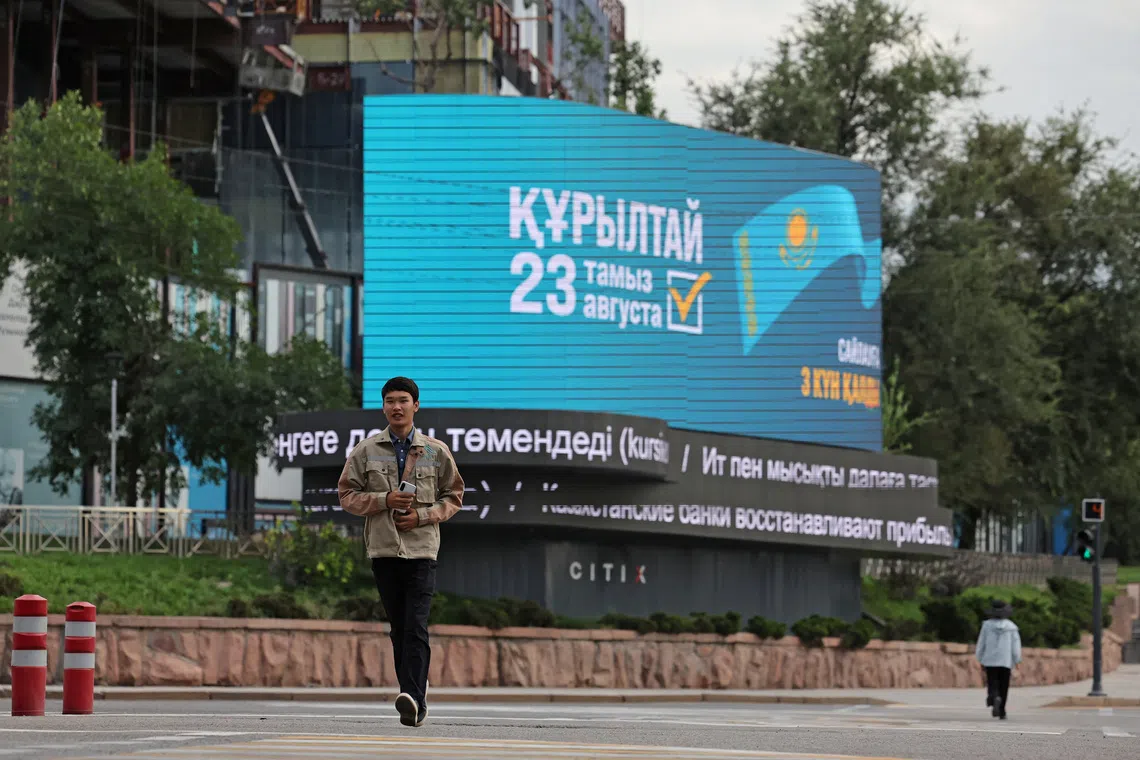 A pedestrian walks past an electronic screen announcing Kazakhstan's upcoming snap parliamentary election in Almaty, Kazakhstan, August 20, 2026. REUTERS/Pavel Mikheyev
