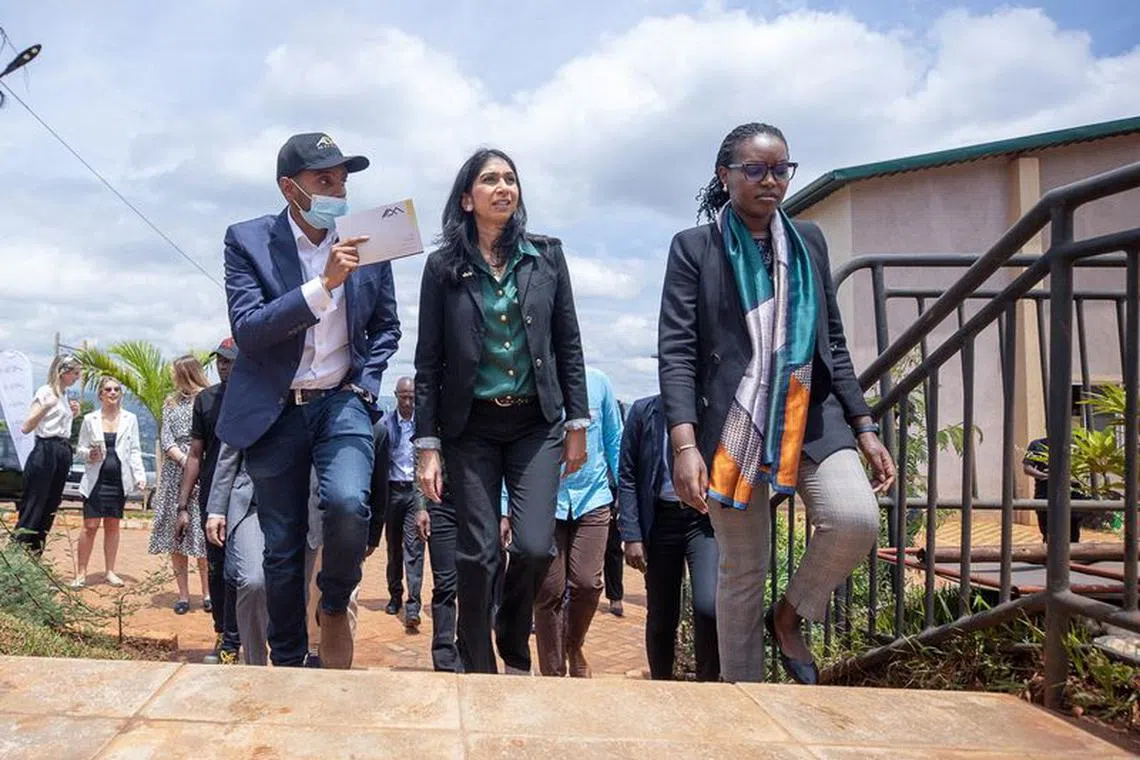 British Home Secretary Suella Braverman walks with Paul Rwigamba, Director of Projects and Property Management and Flora Uwayezu, Project Sales of the Century Real Estate group during a tour in Kigali Rwanda, March 18, 2023. REUTERS/Stringer/File Photo