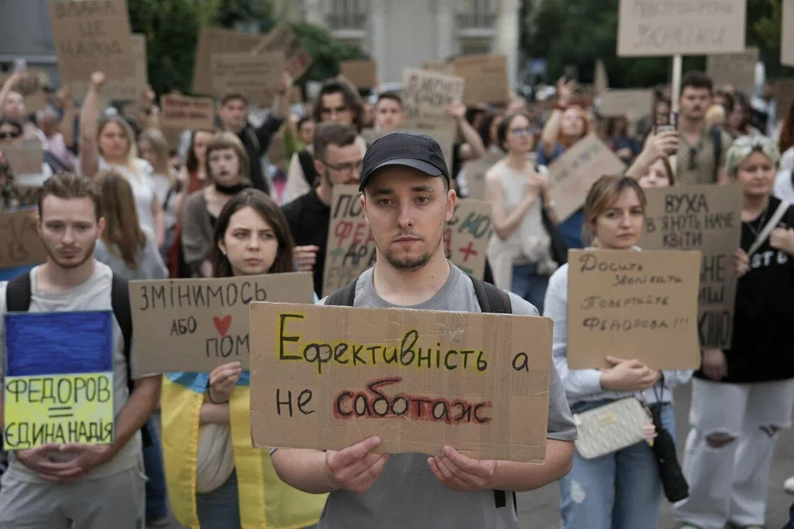 Protesters hold signs during a demonstration supporting former Ukraine Defence Minister Mykhailo Fedorov in Kyiv on July 24.
