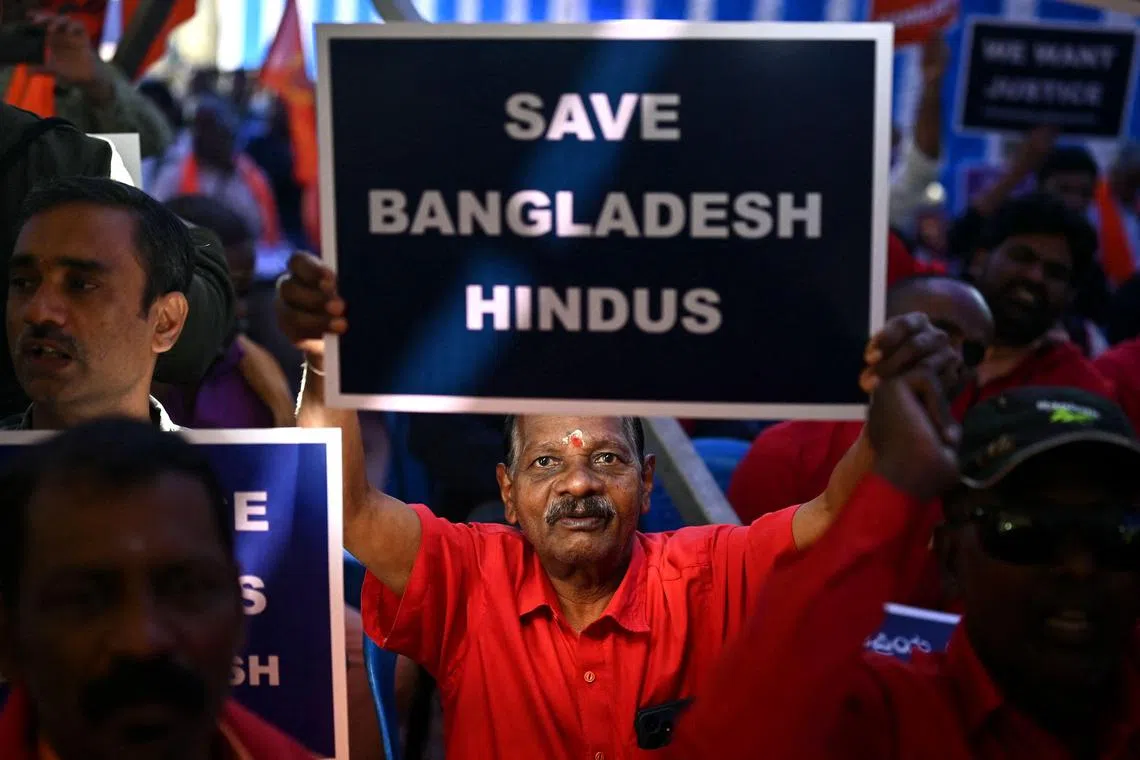 A member of the Hindu Hitarakshana Vedike holds a placard during a protest at Freedom Park in Bengaluru on December 4, 2024, against the violence on Hindu minority community in Bangladesh. Bangladesh on December 3, summoned New Delhi's ambassador after an attack on one of its consulates in India, the latest flare-up in strained ties between the neighbours. (Photo by Idrees MOHAMMED / AFP)