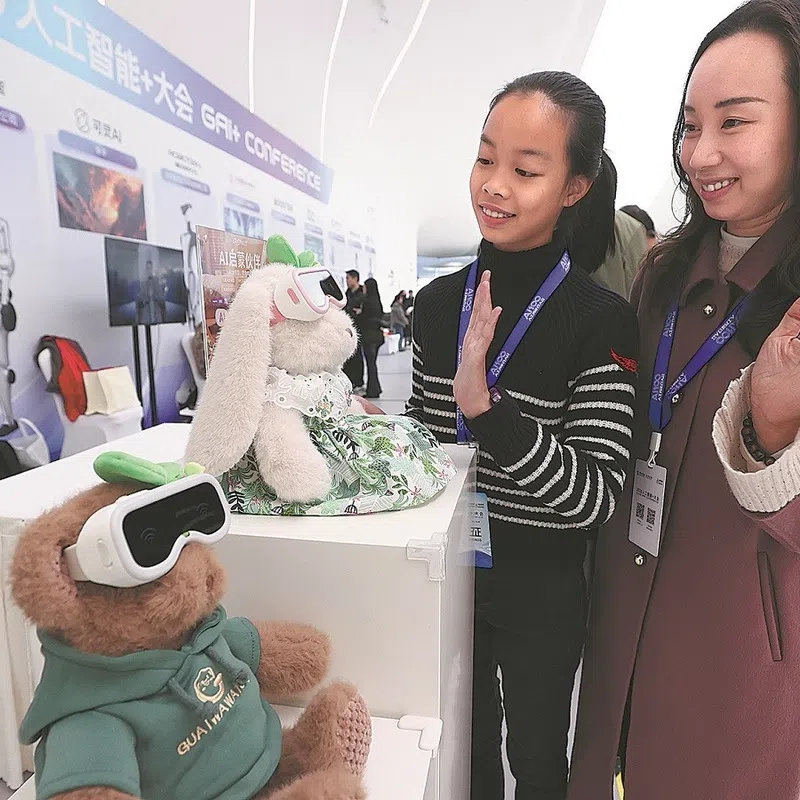 Guests interact with artificial intelligence companion toys on Nov 16 at the 2025 Global AI+ Conference in Beijing.