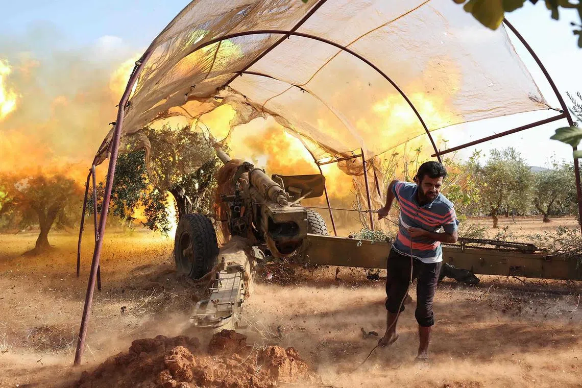 Syrian opposition fighters fire artillery at pro-government forces from a position in the northwestern Idlib province, on Nov 6, 2022, in retaliation for deadly shelling earlier in the day. 